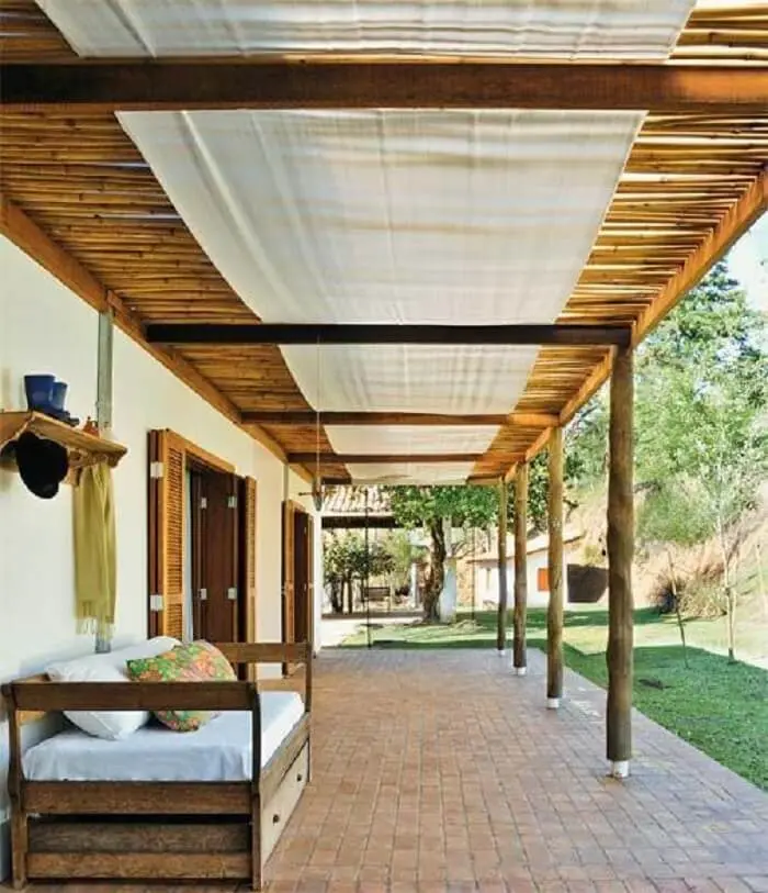 Casa térrea com varanda de madeira e pergolado de bambu