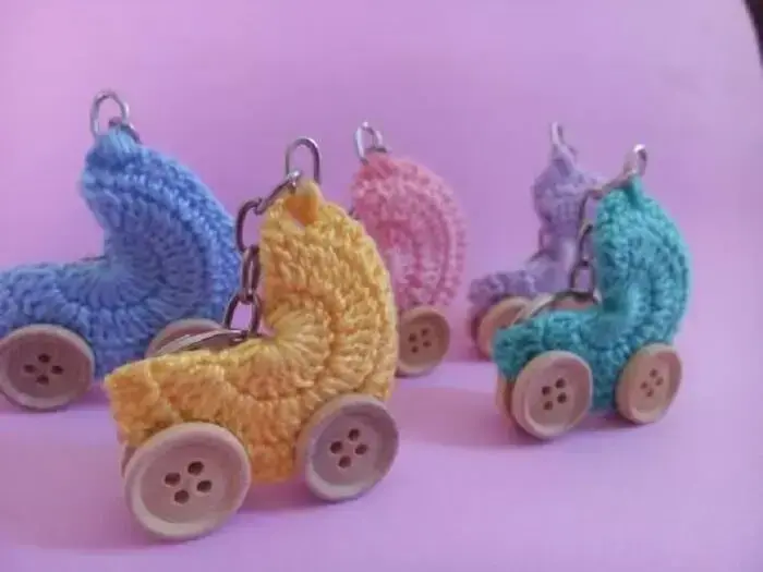Chaveiro de carrinho de bebê em crochê utilizado como lembrancinha de maternidade