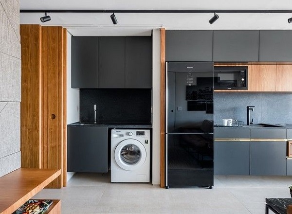 Cozinha com geladeira preta e móveis planejados