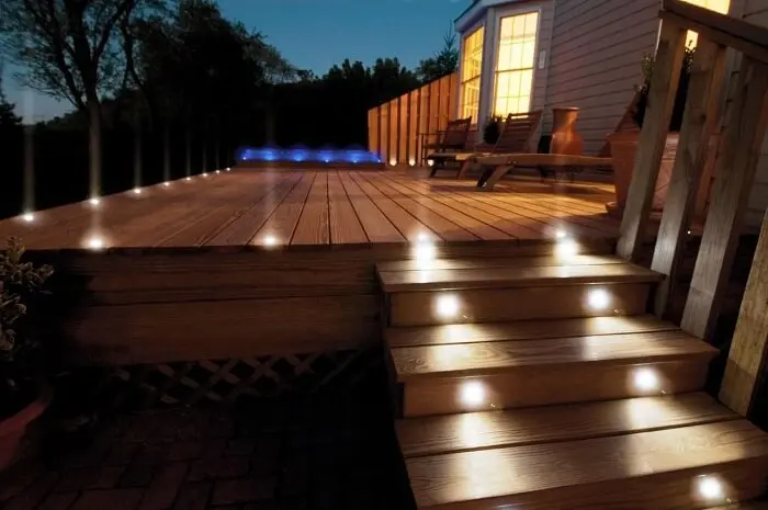 Entrada com varanda de madeira e iluminação especial do jardim