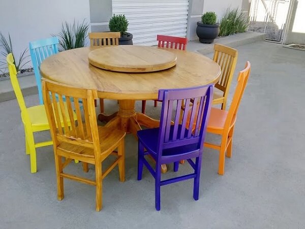 Modelo de mesa redonda com cadeiras de madeira coloridas