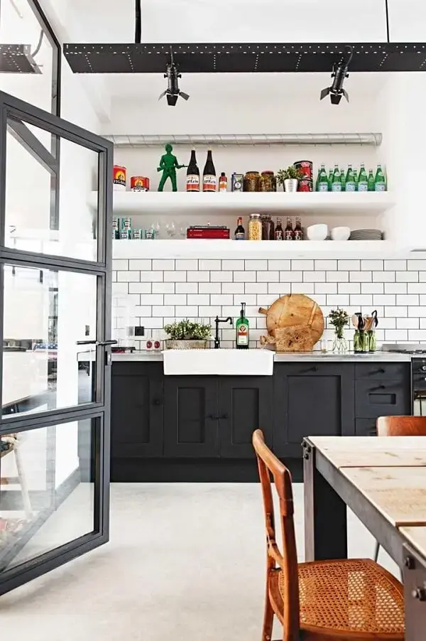 O azulejo branco da cozinha realça os móveis escuros do espaço