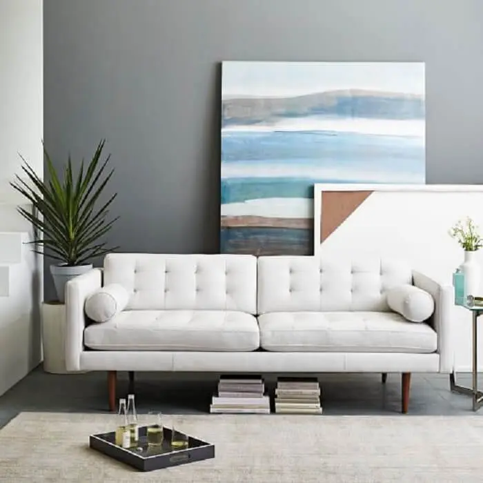 O tecido de sofá de couro em tom branco traz neutralidade para a decoração
