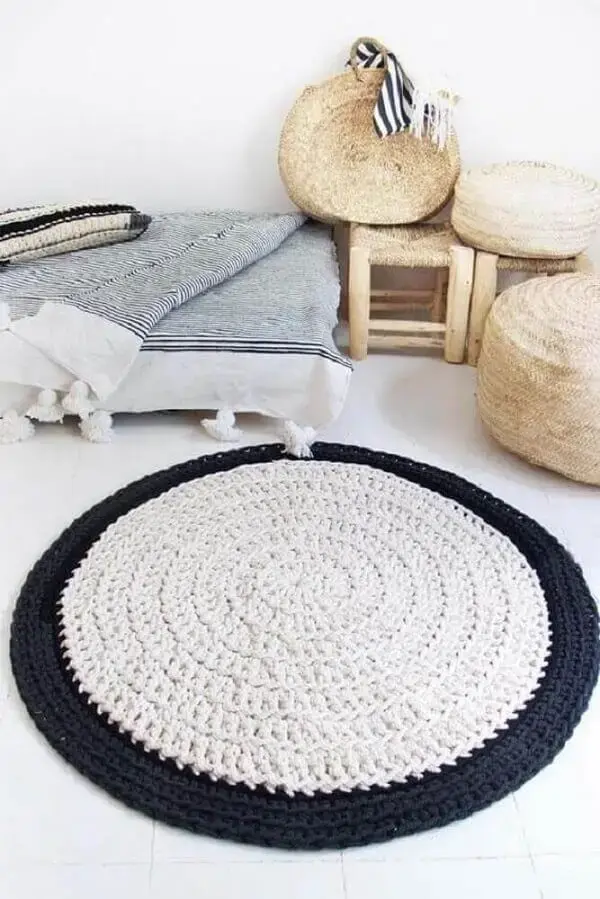 Quarto com decoração clean conta com tapete de crochê preto e branco