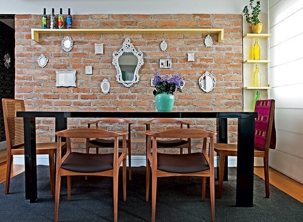 Sala de jantar com parede de tijolinho e cadeira de madeira