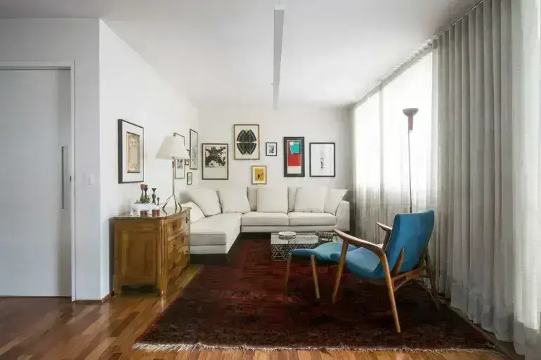 Sala de estar com sofá de canto e poltrona azul. Fonte A.M Studio Arquitetura