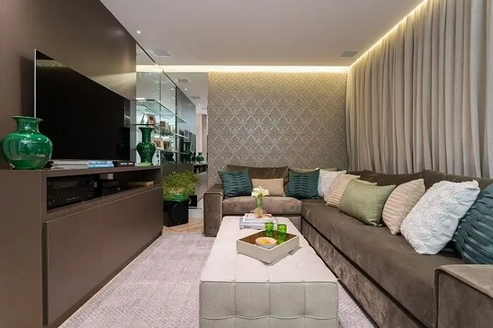 Tecido para sofá de veludo e diversas almofadas complementam a decoração do ambiente