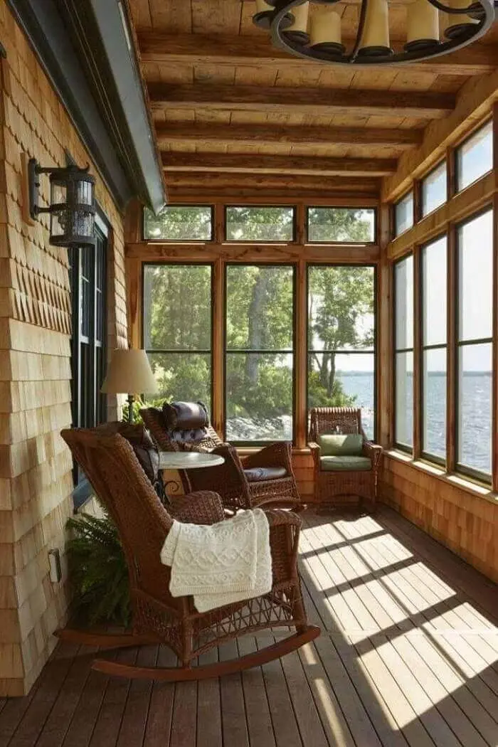Varanda de madeira e cortina de vidro dão a sensação de amplitude no ambiente