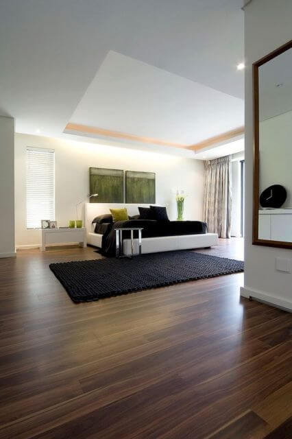 Carpete de madeira no quarto com sofá branco