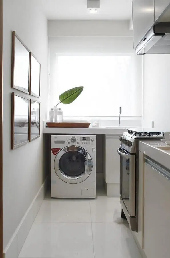 cozinha integrada com área de serviço decorada com cores claras e máquina de lavar e secar Foto Revista VD