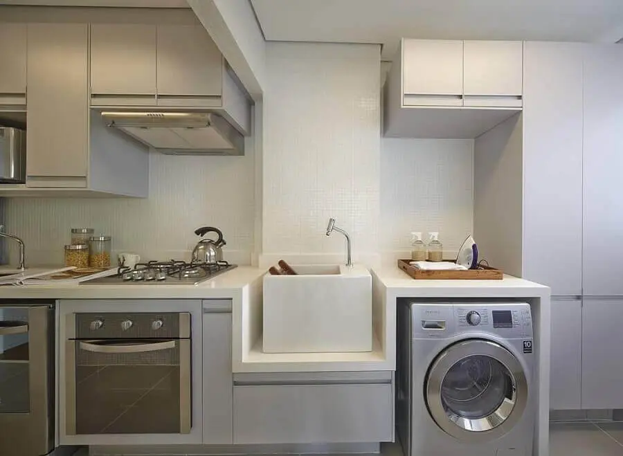 cozinha moderna integrada com área de serviço decorada com máquina de lavar e secar inox e armários planejados Foto Ornare
