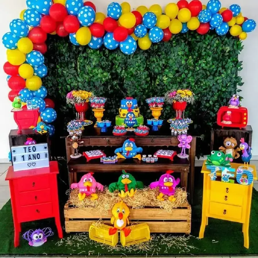 festa da galinha pintadinha simples decorada com painel de folhagens e balões coloridos Foto Navire Festas Decoração