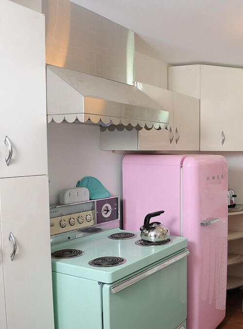 Geladeira cor de rosa na cozinha pequena