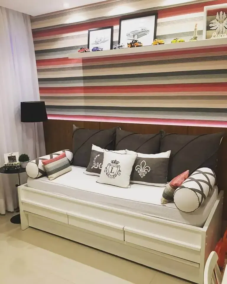 quarto infantil com sofá cama e papel de parede listrado 