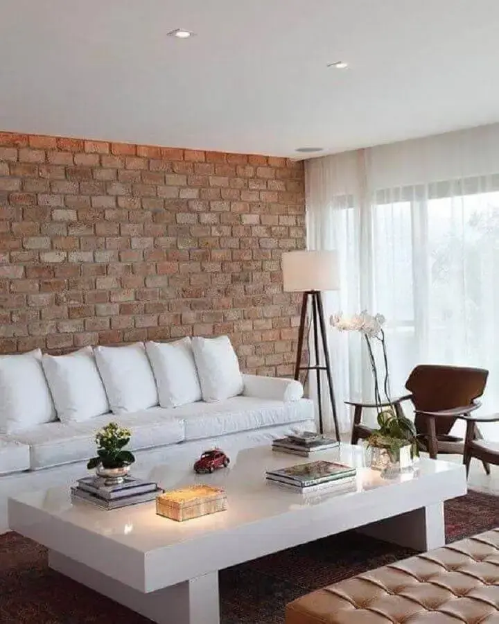 sala de estar decorada com parede de tijolinho e sofá branco de couro Foto Ideias Decor