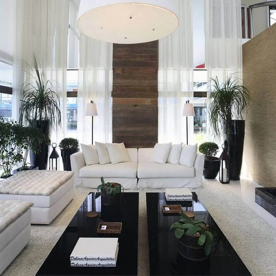 sala sofisticada decorada com sofá branco e mesas de centro pretas Foto Assetproject