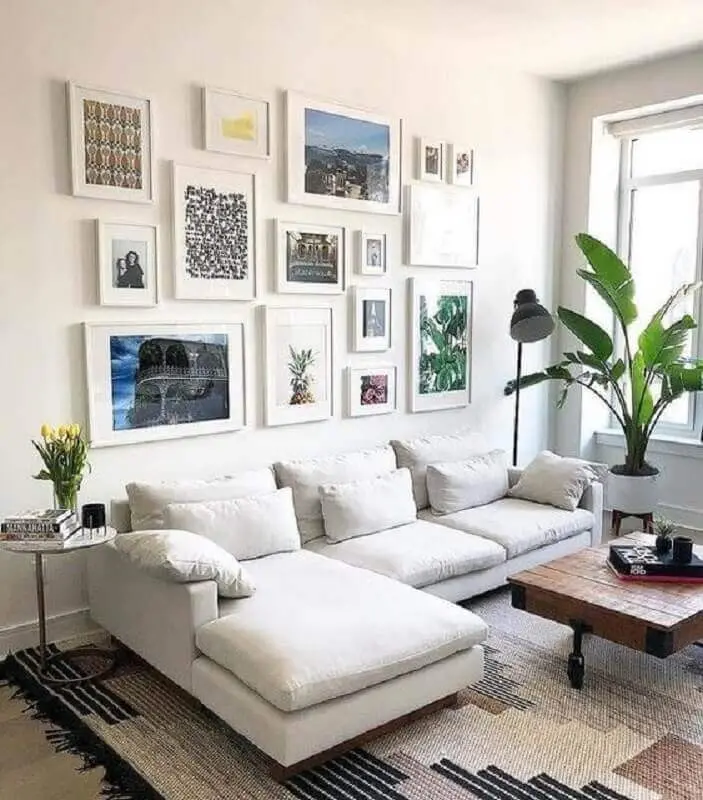 sofá branco com chaise para decoração de sala de estar com vários quadros Foto We Heart It