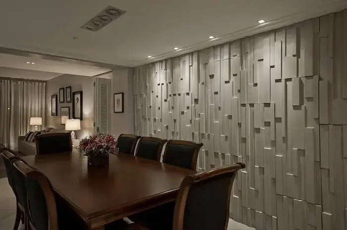 A parede revestida com placa de gesso 3D trouxe elegância e charme para a sala de jantar