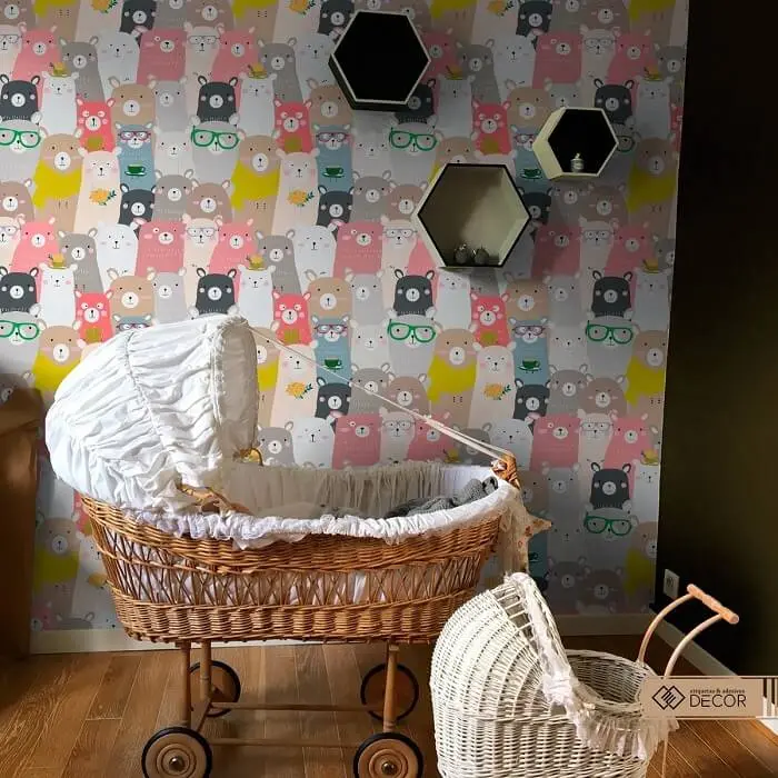 Berço de vime e papel de parede ilustrado para quarto de bebê