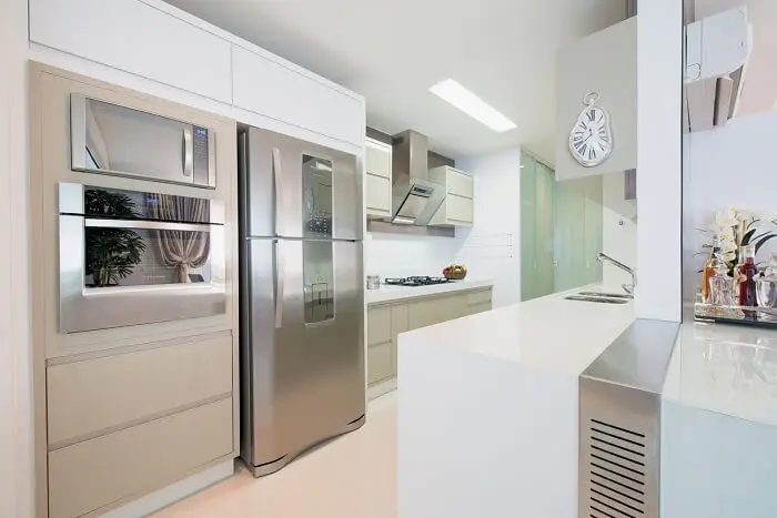 Cozinha com bancada branca e relógio de parede com design criativo