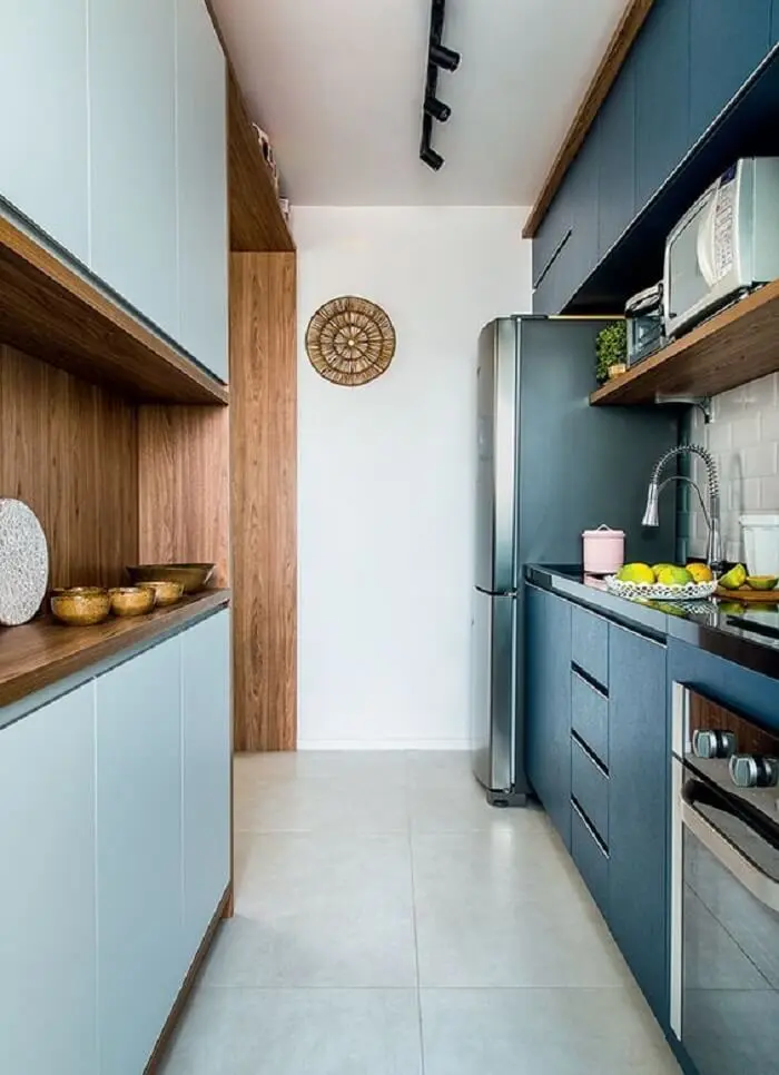 Cozinha compacta com marcenaria azul, iluminação preta e torneira gourmet