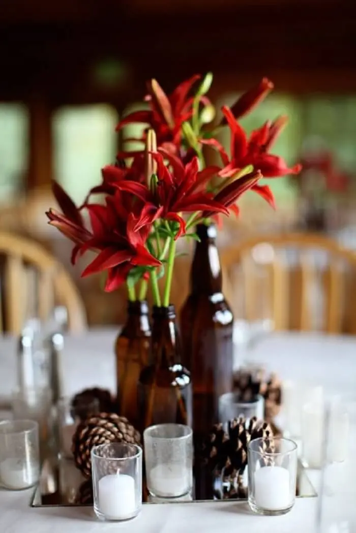 Decoração do centro de mesa para festa Chá Bar feita com garrafas de vidro e flores