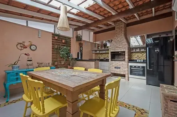 Espaço gourmet com mesa com cadeiras amarelas