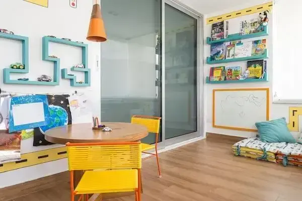 Espaço infantil com prateleira azul e cadeira amarela com detalhes em laranja