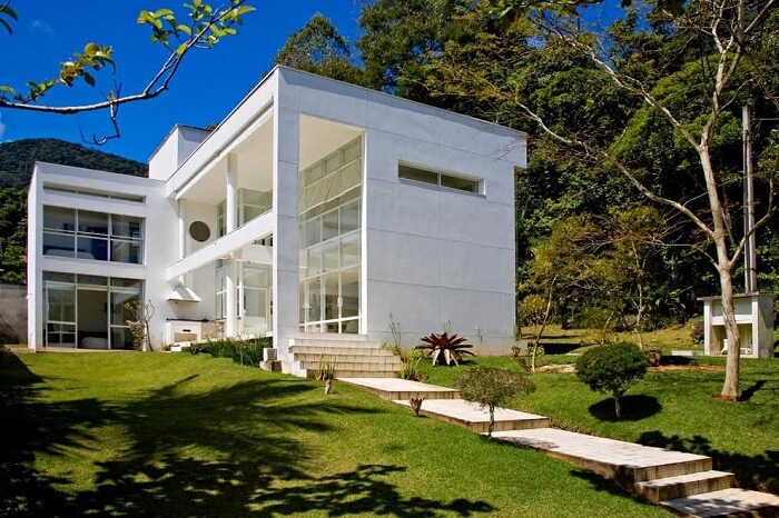 Fachada moderna com janelas largas de vidro e esquadrias de alumínio branco