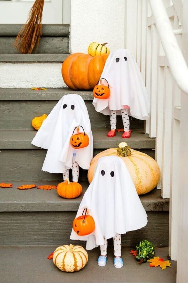 Festa de Halloween decorada com aboboras e crianças vestidas de fantasmas Foto Brit Morin