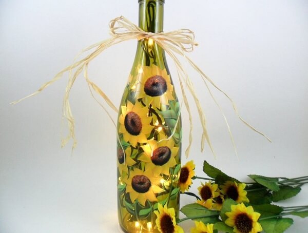 Flores de girassóis e luzes trazem vida para as garrafas decoradas