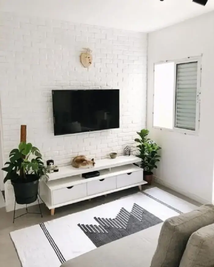 O rack retrô em tom branco manteve o estilo clean do projeto da sala de estar