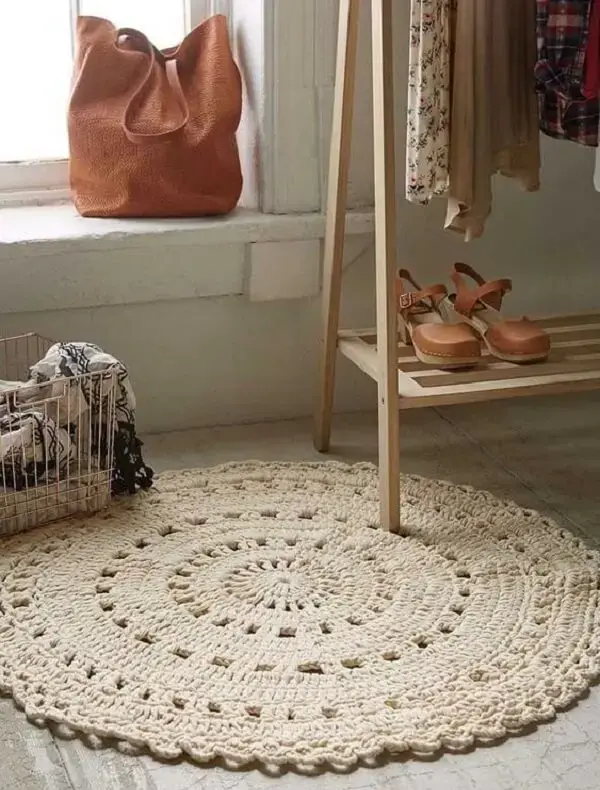O tapete de crochê redondo complementa a decoração do ambiente e serve de conforto aos pés