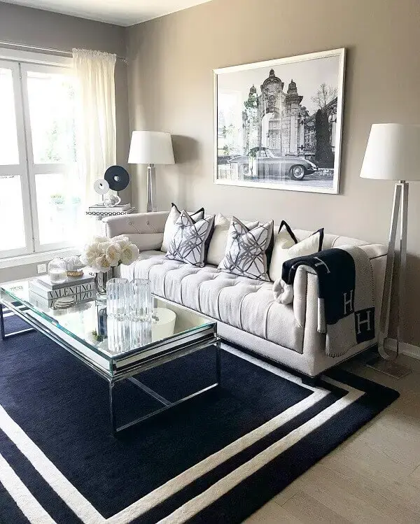 O tapete preto e branco se conecta com a decoração clássica da sala de estar