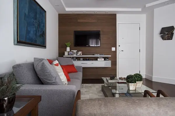 Otimize o espaço da sala de estar investindo em um rack suspenso. Projeto de Lili Giudice