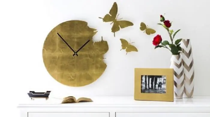 Relógio de parede em tom dourado com borboletas