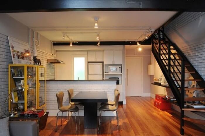 Sala com escada e cozinha americana branca