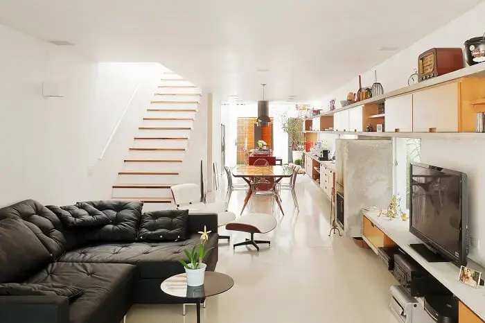 Sala com escada e cozinha americana se harmonizam na decoração