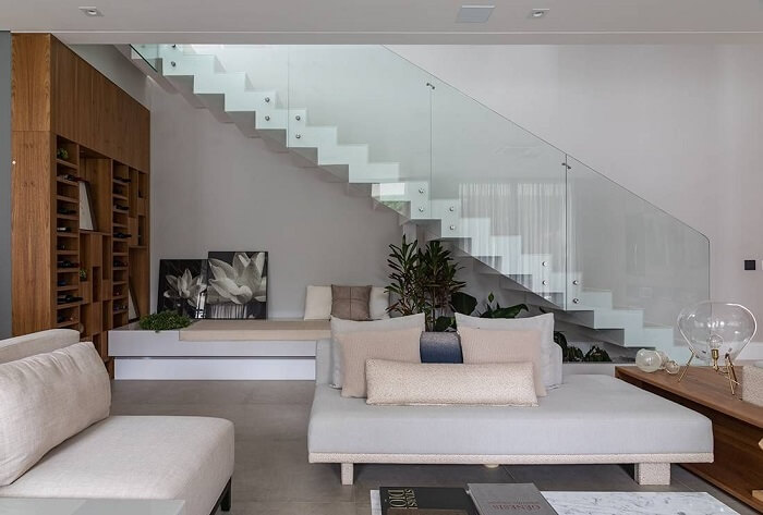 Sala com escada flutuante com guarda corpo de vidro