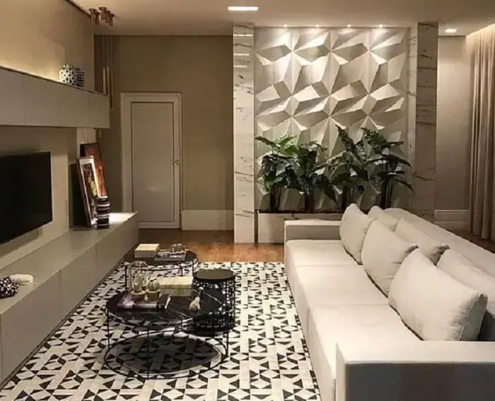 Sala de estar ampla com sofá três lugares e parede com placa de gesso 3D