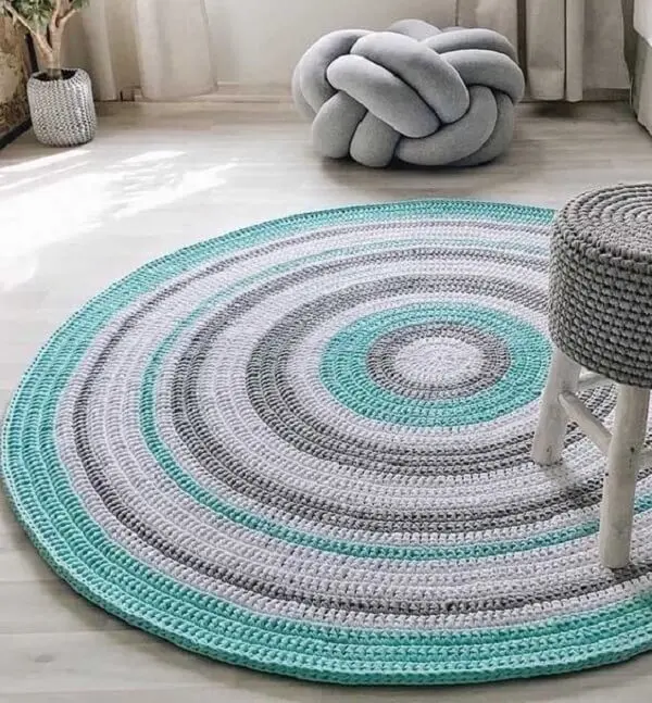 Sala de estar clean com tapete de crochê redondo colorido