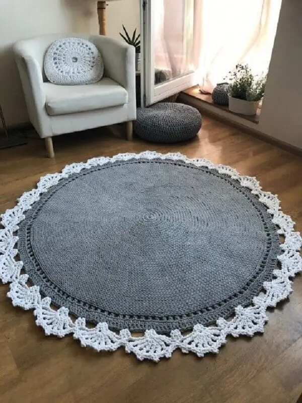 Sala de estar com poltrona e tapete de crochê redondo em tom branco e cinza