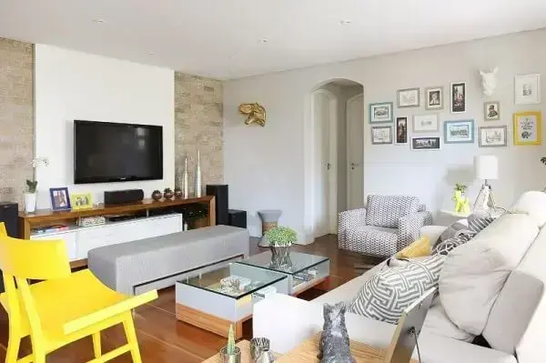 Sala de estar com sofá branco e cadeira amarela