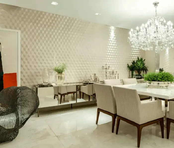 Sala de jantar com decoração clean e parede com placa de gesso 3D e lustre de cristal