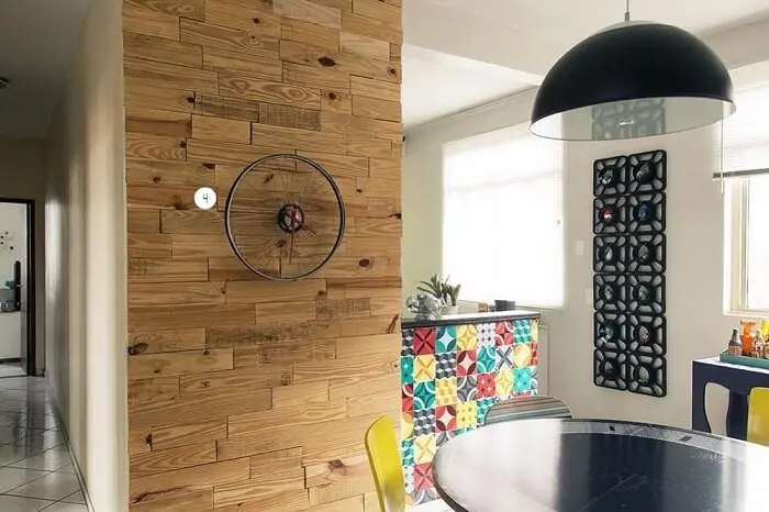 Sala de jantar com relógio de parede feito com aro de bicicleta