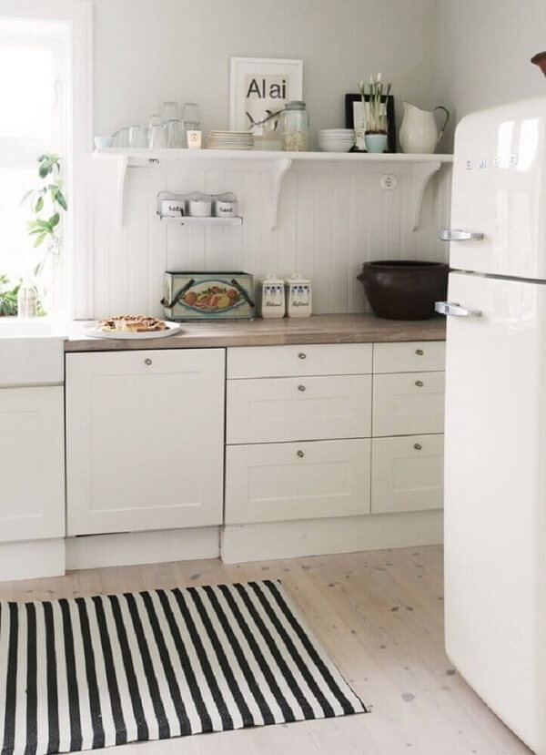 Tapete preto e branco listrado posicionado em frente a bancada da cozinha