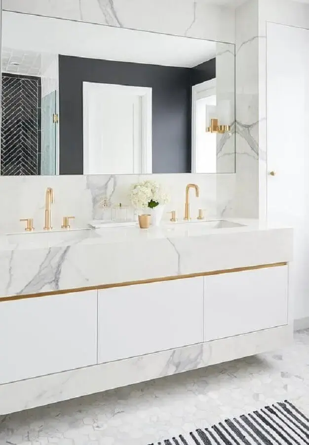 banheiro feminino decorado com bancada de mármore e torneira dourada Foto Decorpad