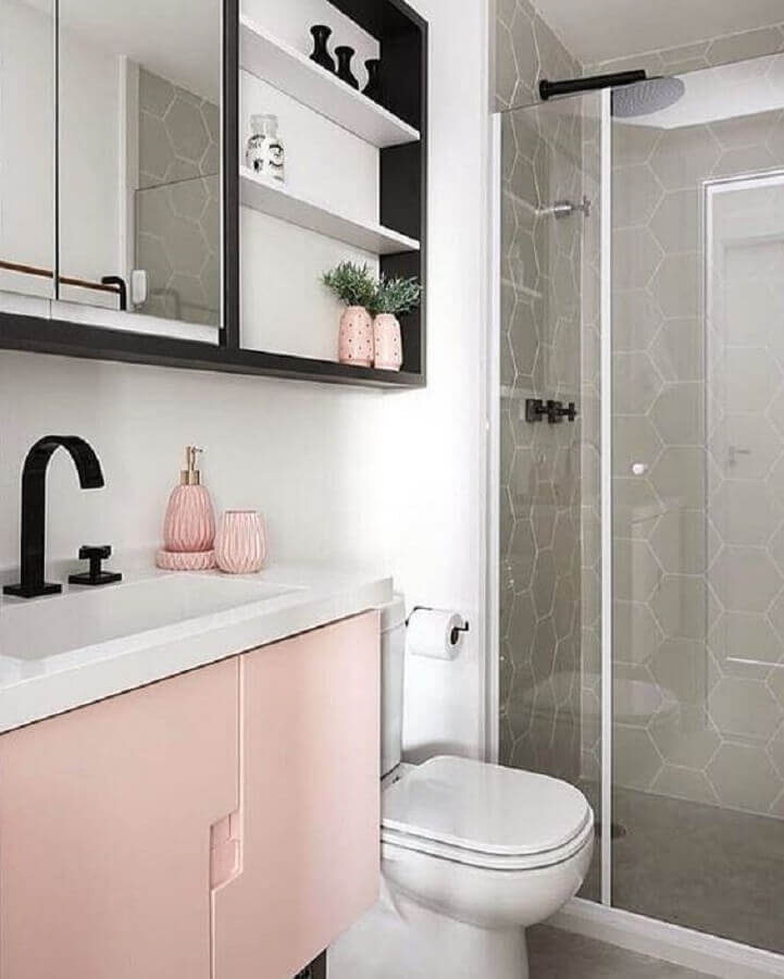 banheiro feminino decorado com gabinete rosa e revestimento cinza hexagonal dentro do box Foto Pinterest