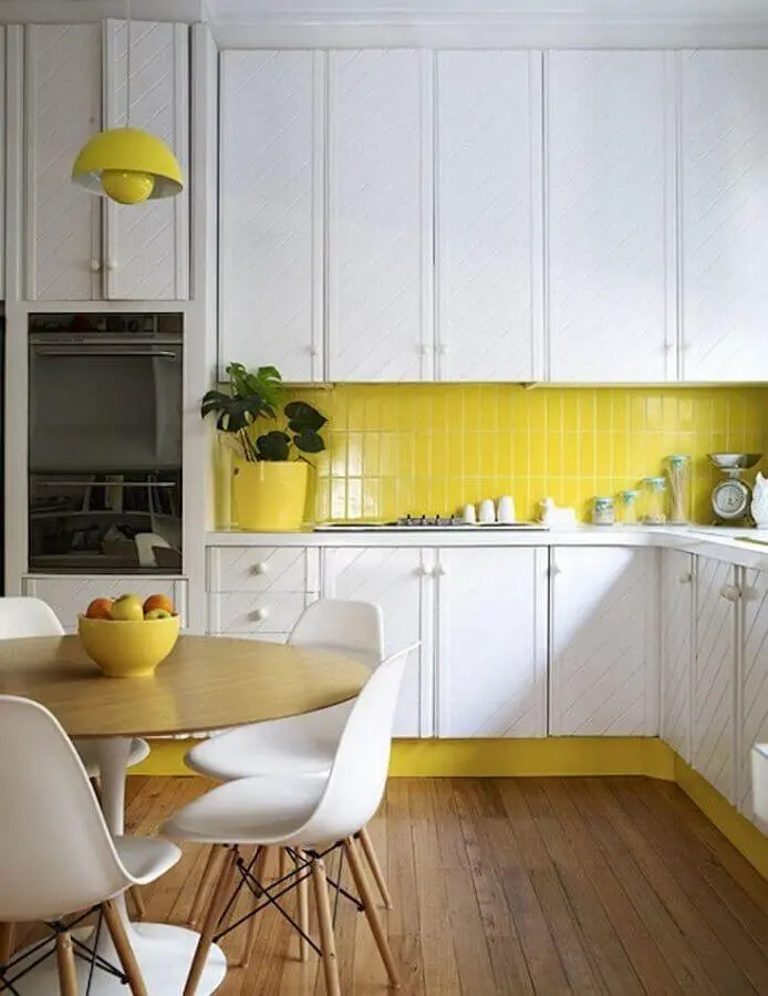 cozinha amarela e branca decorada com mesa redonda e armários planejados Foto Homedit
