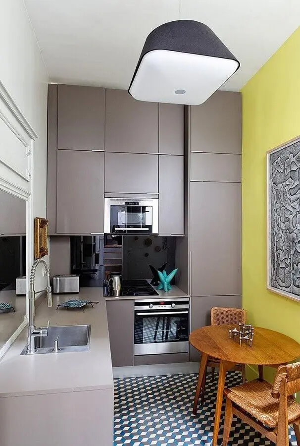 cozinha cinza e amarela decorada com armários planejados e mesa redonda de madeira Foto HomeServe